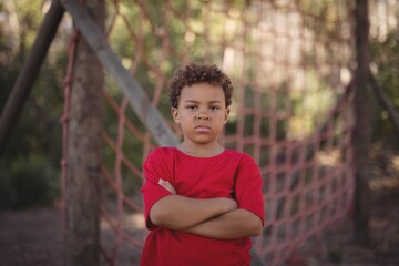 Boy standing with arms crossed during obstacle