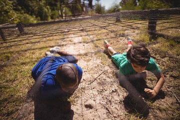 Kids crawling under the net during obstacle course