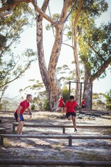 Trainer instructing kids during obstacle course training