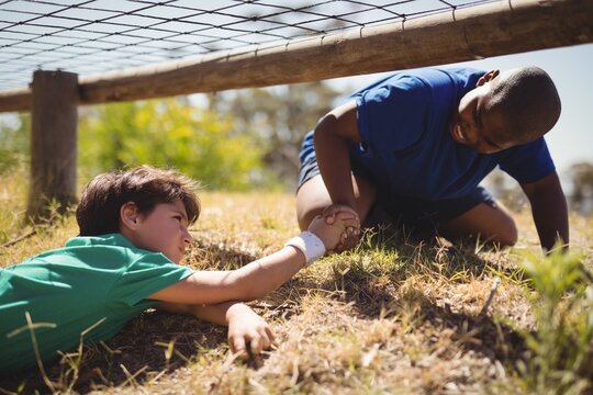 Boy helping his friend during obstacle course