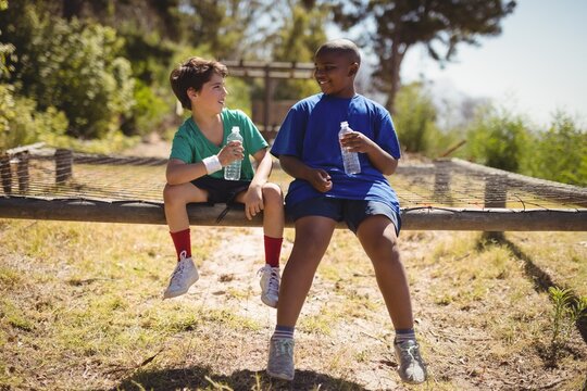 Happy friends relaxing after workout during obstacle course