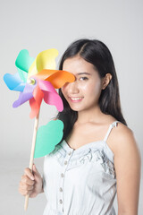 Young cute asian girl smiling with wind turbine toy