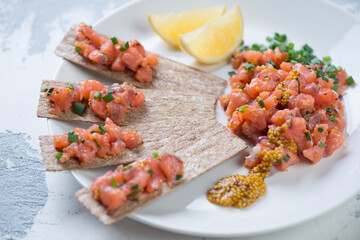 Close-up of a white plate with salmon tartar, selective focus, horizontal shot