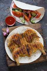 Wooden serving board with georgian traditional tapaka chicken, selective focus, studio shot