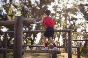 Boy walking on obstacle during obstacle course