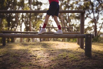 Low section of kid walking on obstacle during obstacle course