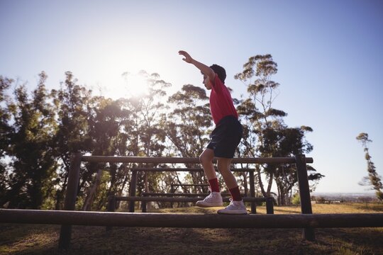 Boy walking on obstacle during obstacle course