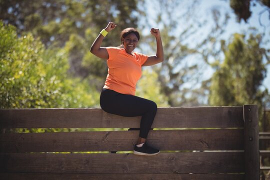 Portrait of happy woman cheering on wooden wall