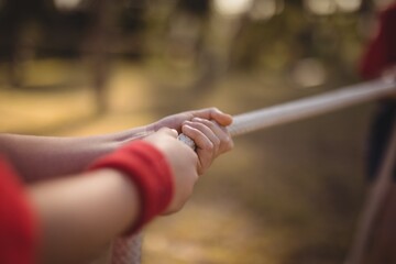 Hands of kid practicing tug of war during obstacle course