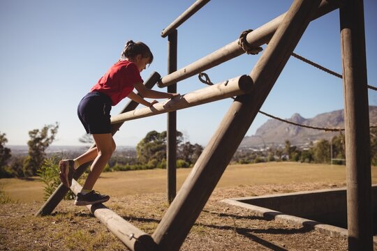 Girl exercising on outdoor equipment during obstacle course