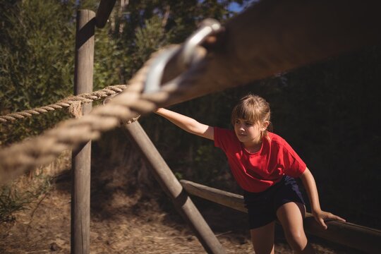 Determined girl exercising on outdoor equipment