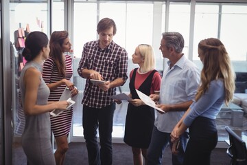 Naklejka premium Businessman discussing strategies with team in creative office
