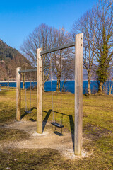 Fototapeta premium Kinderspielplatz mit Schaukeln an einem See