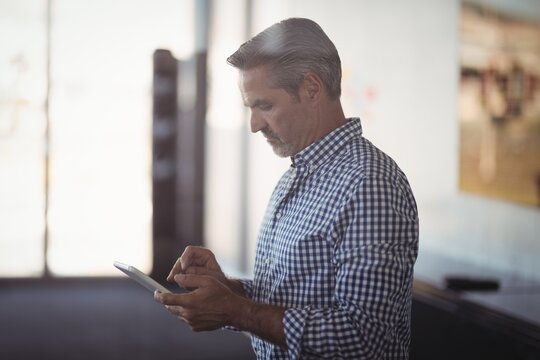 Mature businessman using digital tablet at office