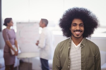 Smiling businessman with colleagues in office