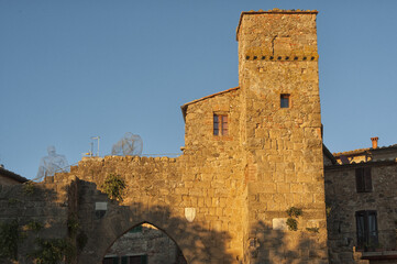 Fototapeta premium Montichiello - Italy, October 29, 2016: Quiet street in Montichiello, Tuscany with typical shuttered windows and paved streets. Monticchiello is the only fraction of the municipality of Pienza, in th