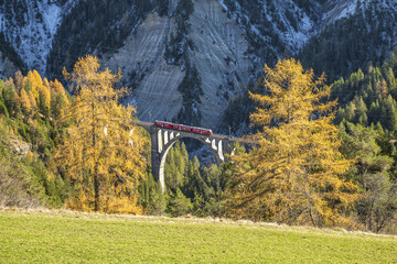 Bernina Express passes through Wiesner Viadukt surrounded by colorful woods Canton of Graub&Atilde;&frac14;nden Switzerland Europe