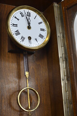 Wall wooden clock with pendulum in vintage style