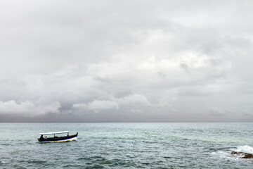 A speedboat sails near the rocks near Salvador, Brazil