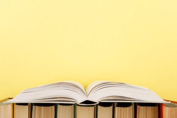 education and wisdom concept - open book on wooden table, color background
