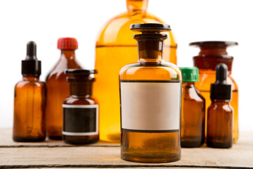 Pharmacy container with blank label and vintage medical bottles on the background