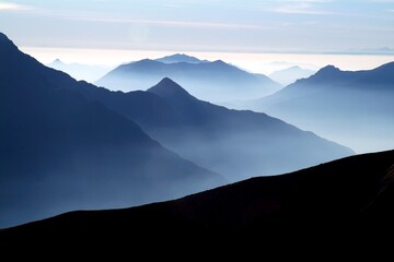 The ridges of the lake follow each other in the direction of the Po Valley with the mist to...