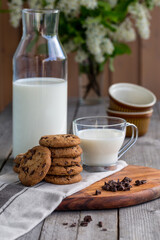 Obraz na płótnie Canvas Chocolate chip cookies with milk on old rustic wooden table