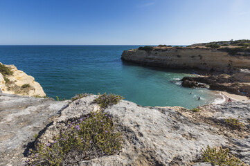 Fototapeta na wymiar The turquoise water of the ocean surrounded by cliffs at Praia De Albandeira Algarve Lagoa Faro District Portugal Europe