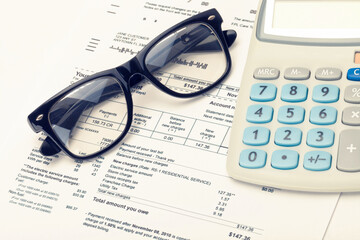 Calculator with utility bill under it. Filtered image: cross processed vintage effect.