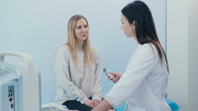 A woman communicates with a sonographer in clinic
