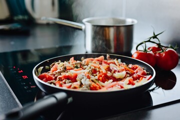 Frying minced pork with vegetables on olive oil.