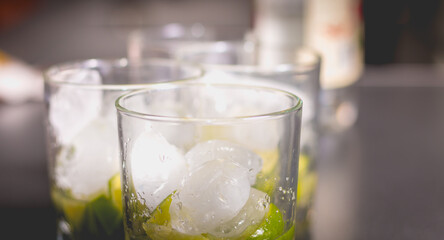 Caipirinha glass with icicle on black background
