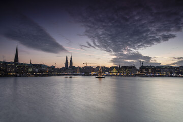The colors and lights of dusk on Inner Alster Lake with the Christmas Tree suspended in its water Hamburg Germany Europe