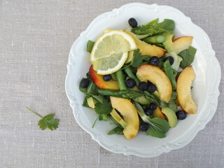 Vegetarian salad from cabbage pak choy, green asparagus, blueberries and nectarine