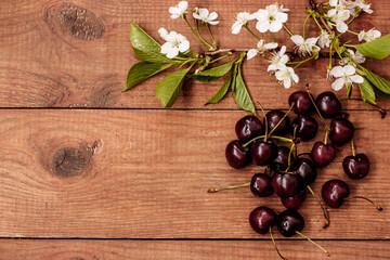 the cherry blossoms and cherries on a wooden table