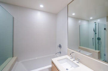Modern bathroom interior with bathtub, sinks, and shower cabin.