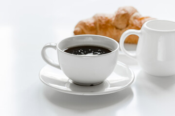 coffee, milk and croissant for breakfast of businessman white office desk background