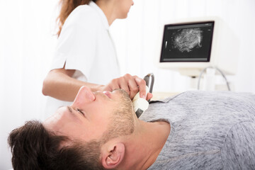 Obraz na płótnie Canvas Man Getting Ultrasound Of A Thyroid From Doctor