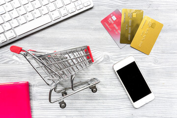 office desk with trolley, mobile and cards for online buying on light background top view mock-up