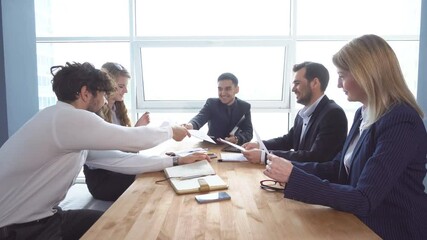 Group of young businessman at the negotiating table in the office. Colleagues look through documents. a business meeting.