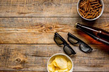 glasses, snacks, beer for whatchig film on wooden background top view space for text