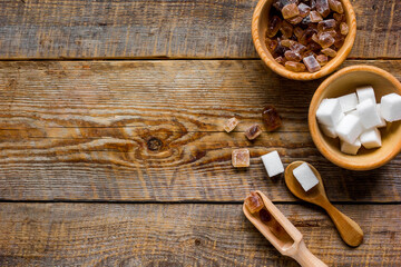 lumps of white and brown sugar on wooden table background top view mock up