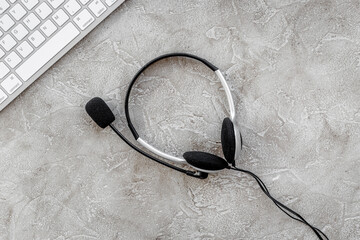 call center manager work with headset on stone desk background top view