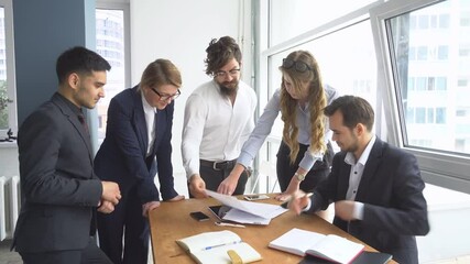 Managers view the documents in the office. Colleagues at office desk. Director of the company holds a meeting with his subordinates