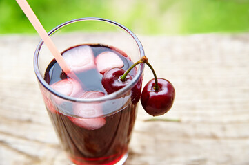 Cherry juice in glass with ice outdoors view from above