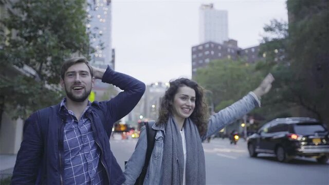 Couple hailing taxi on street