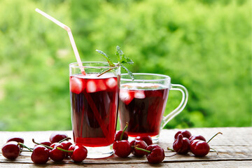 Cherry juice in glasses with ice and mint On the rustic table