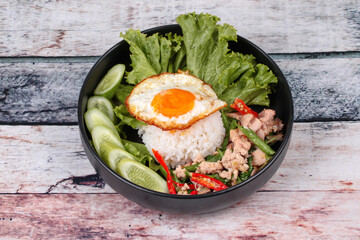 Jasmine rice topped stir - fried spicy basil with meat.