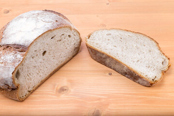 Sliced rustic medieval loaf of bread on a natural wood oak board