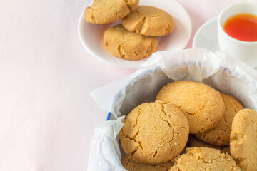 Homemade Gingernuts with Tea from Above on Pastel Pink Table Cloth with Copy Space